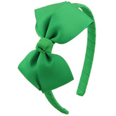7Rainbows emerald green bow headband on a child, adding cute style and tidy hair.