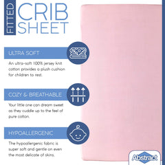 Abstract pink crib sheet on a mattress shows snug, secure fit.