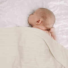 AQOKKA swaddle fabric close-up, smooth stretch and gentle touch.