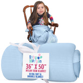 Baby Morgan blue waffle blanket shown in a cozy crib setup for soft naps.