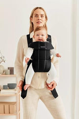 BabyBjörn Carrier Mini shows newborn facing-in position with ergonomic support.