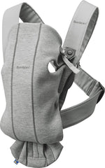 BabyBjörn Mini carrier in light gray front view with ergonomic newborn support.