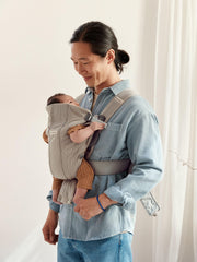 BabyBjörn Mini newborn position with back support promoting comfortable hip alignment.