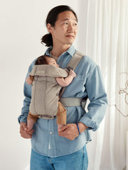 BabyBjörn Mini soft fabric close-up in gray beige for gentle skin contact.