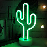 Bailey green cactus neon light on pedestal illuminating a desk setup