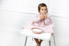 Bibado coverall bib features wipe-clean waterproof fabric for quick mess cleanup.
