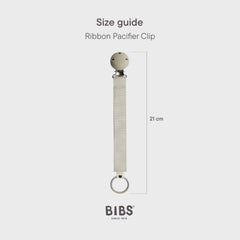 BIBS pacifier clip ribbon blush worn on a baby outfit demonstrates hands-free convenience
