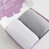 Biloban bassinet sheets 2-pack in white and gray with soft cotton fabric for cozy naps.