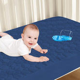 Biloban crib mattress protector waterproof cover shown on a crib mattress for spill protection and easy cleanup