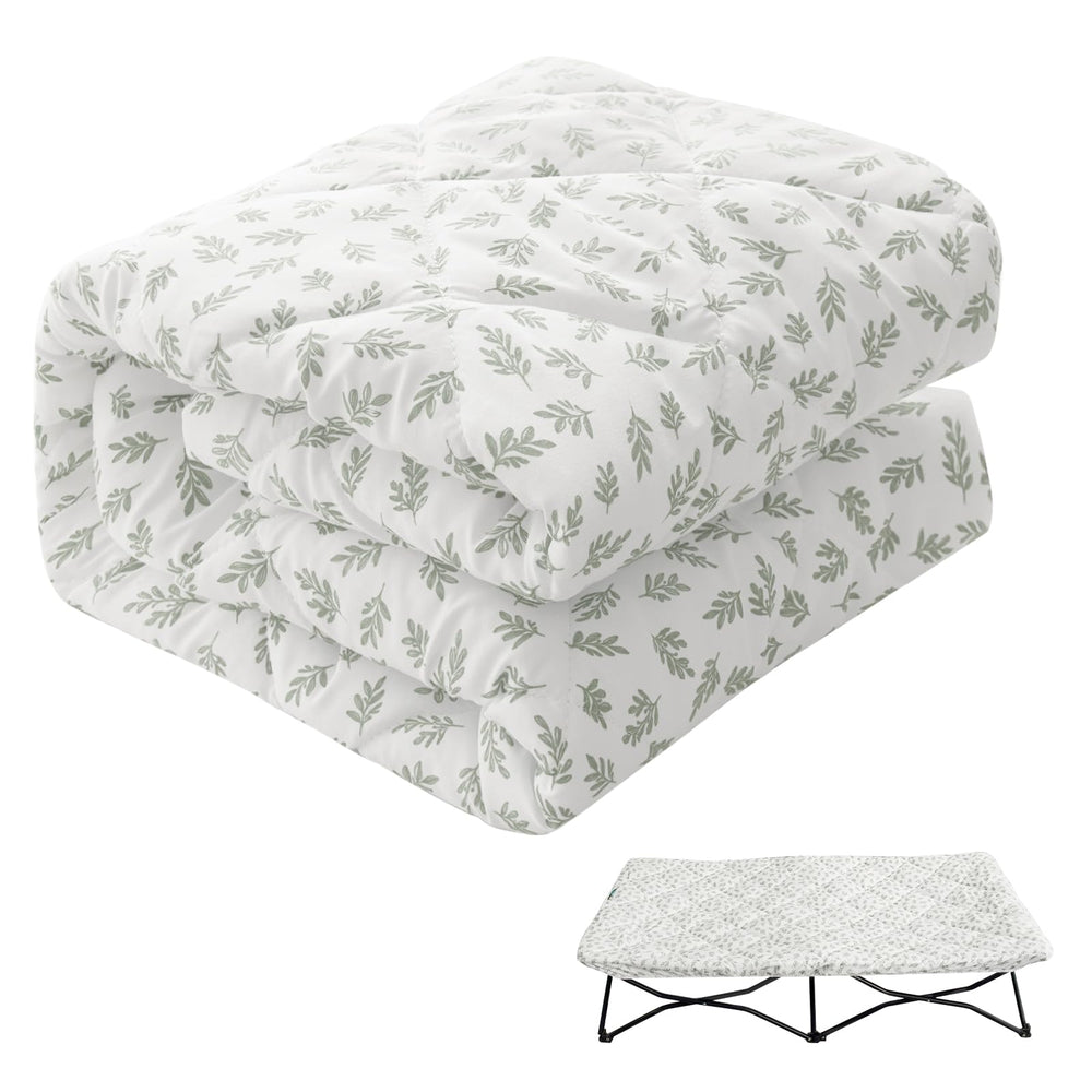 Biloban Regalo My Cot sheet in green leaf on bed offers cozy travel comfort.