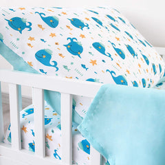 Biloban Whale toddler sheet fitted on bed shows secure elastic edges.