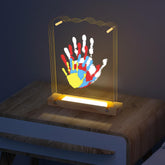 Bixinyo family handprint kit light on a wooden base creates a warm, cozy night glow.