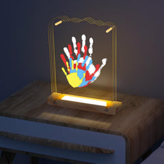 Bixinyo family handprint kit light on a wooden base creates a warm, cozy night glow.