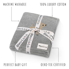 Bleu La La knit swaddle in deer grey draped over crib for calm sleep