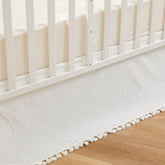 Brandream crib skirt in cream with tassel fringe enhances neutral nursery decor.