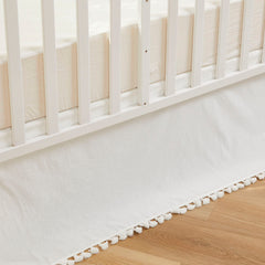Brandream crib skirt in cream with tassel fringe enhances neutral nursery decor.