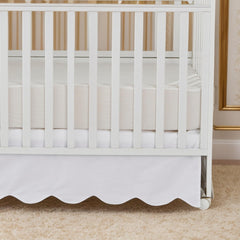 Brandream scallop edge crib skirt side view with elegant drape.