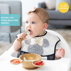 Bumkins bib shows crumb catcher pocket catching spills during self-feeding.