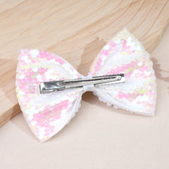 CÉLLOT glitter bow hair clip worn by toddlers for charming dress-up moments.