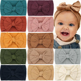 CÉLLOT soft knot headband with bow in cream, gentle elastic for newborn to toddler comfort.
