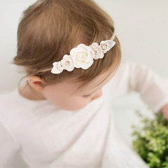Cherrboll headbands on a baby during a photoshoot for a cute accessory look.
