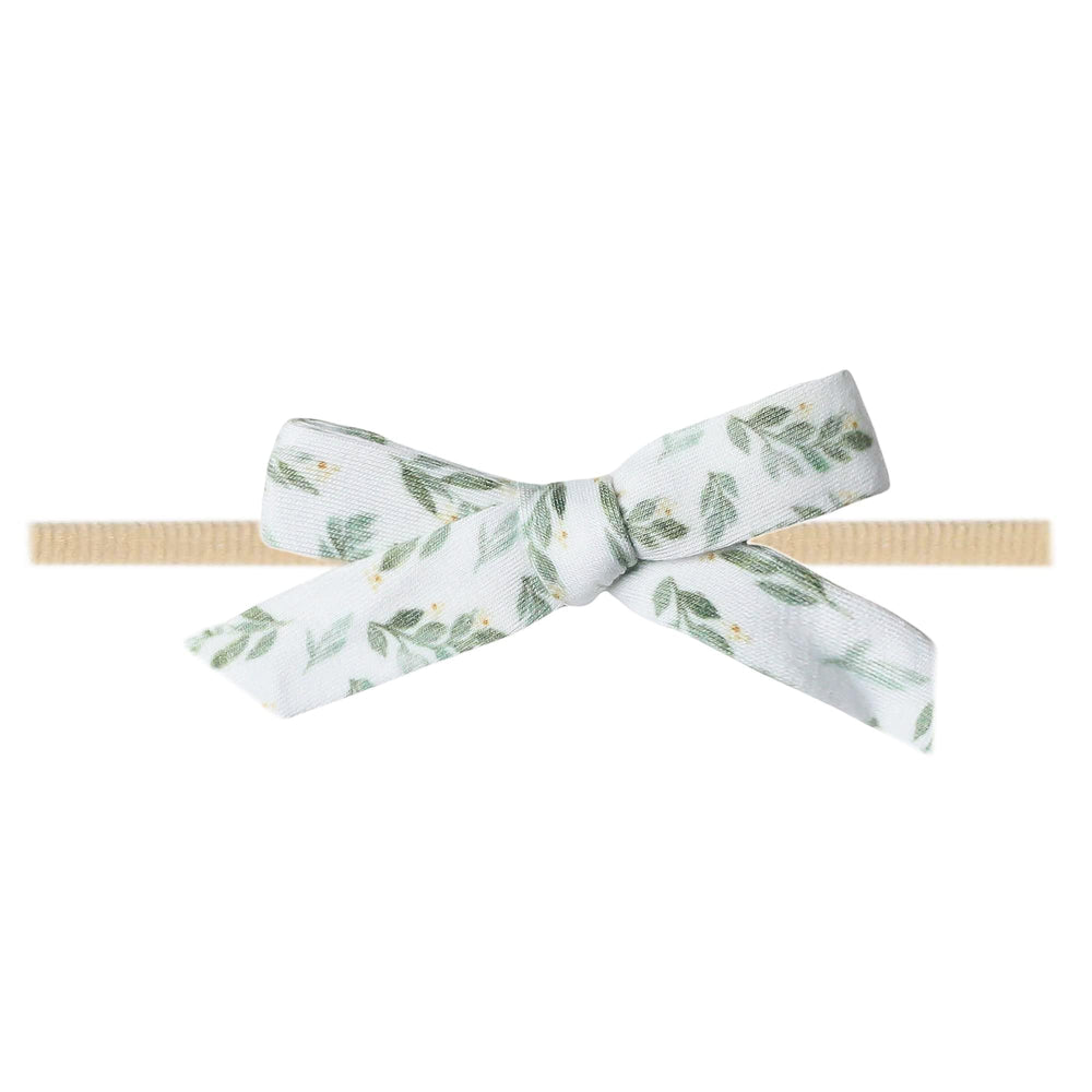 Copper Pearl floral polka dot baby bow on a soft stretch headband for newborn comfort.