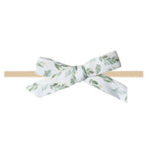Copper Pearl floral polka dot baby bow on a soft stretch headband for newborn comfort.