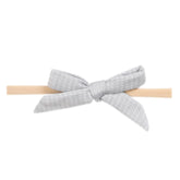 Copper Pearl baby bows on a soft newborn headband for gentle, comfortable wear