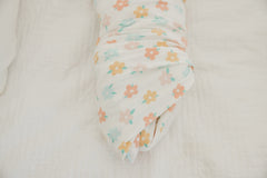 Copper Pearl Daisy swaddle blanket worn as baby wrap during cuddles.