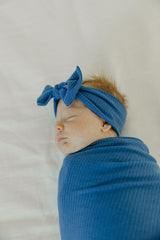 Copper Pearl Indigo swaddle blanket on baby demonstrates gentle swaddling