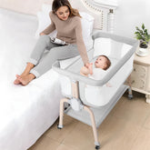 Cowiewie bassinet bedside sleeper fully assembled beside a bed for nighttime feeds.