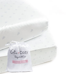 CutieCozy satin fitted crib sheet in white with gray hearts and stars protects delicate baby curls.