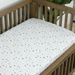 Dreamology Planets crib sheet on mattress demonstrates snug elastic-edge fit