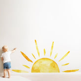Duocheer half sun wall decal adds warm glow to living room ambiance.