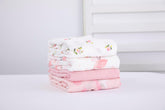 Flexora Muslin Swaddle Blanket Pink Dreams wrapped around a sleeping newborn.