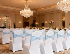 Baby blue sashes stretched along chair backs for uniform appearance.