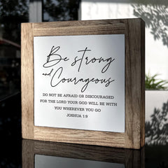 Gkwa Joshua 1:9 sign displayed on desk with warm lighting