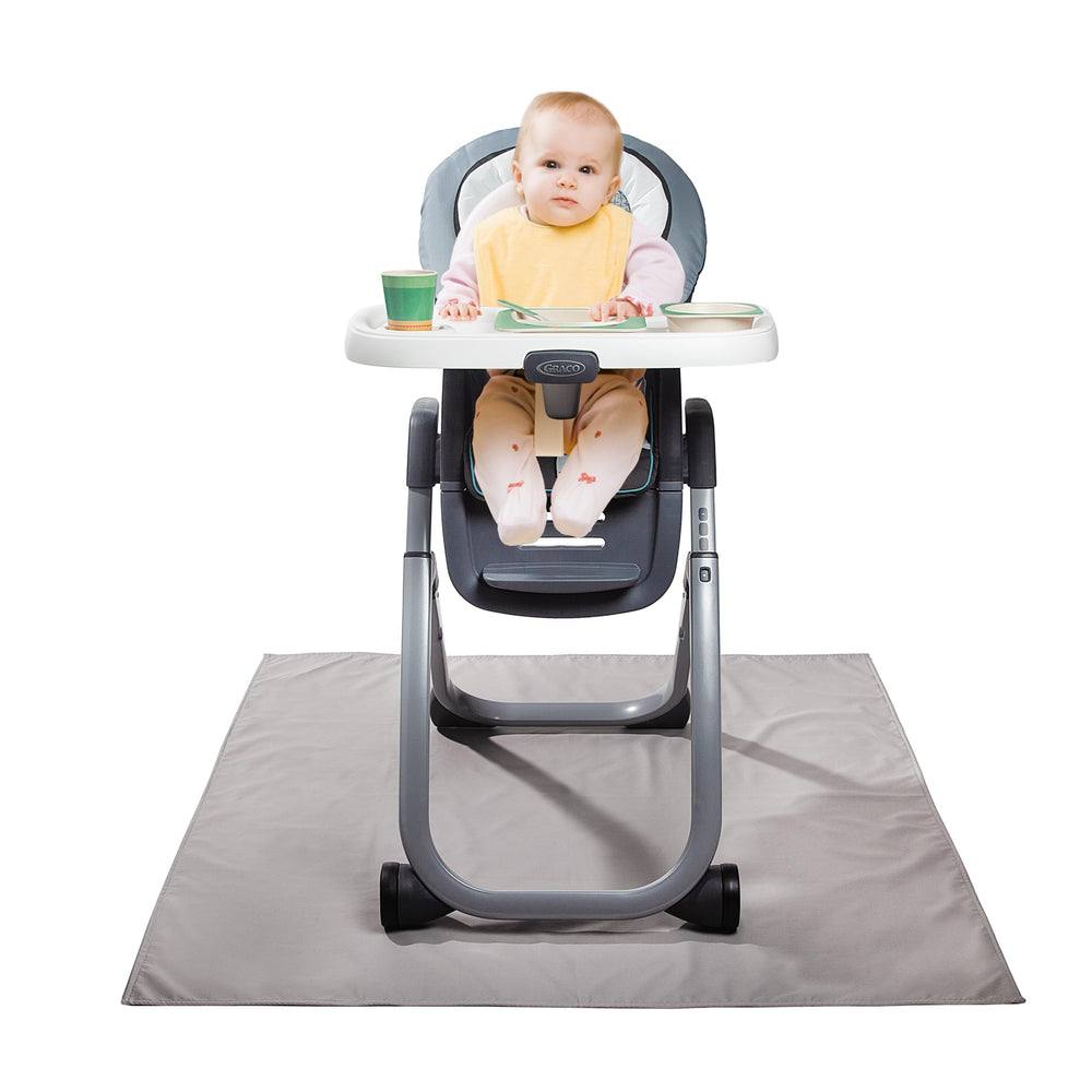 Graco splat mat under high chair protects floors from spills and messes.