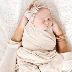 GRSSDER swaddle blanket set with headband showcases gender-neutral, cozy newborn essentials.