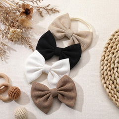 HairChrysm soft baby bow headband in white for clean photo looks.