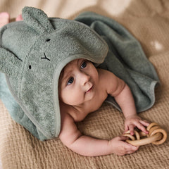 Huxie baby towel draped on a newborn indicating warmth and comfort