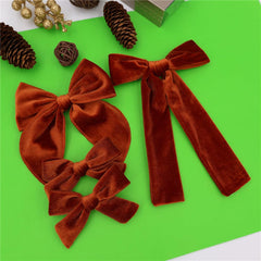 Jomila copper velvet bow clip closeup shows soft texture and grip.