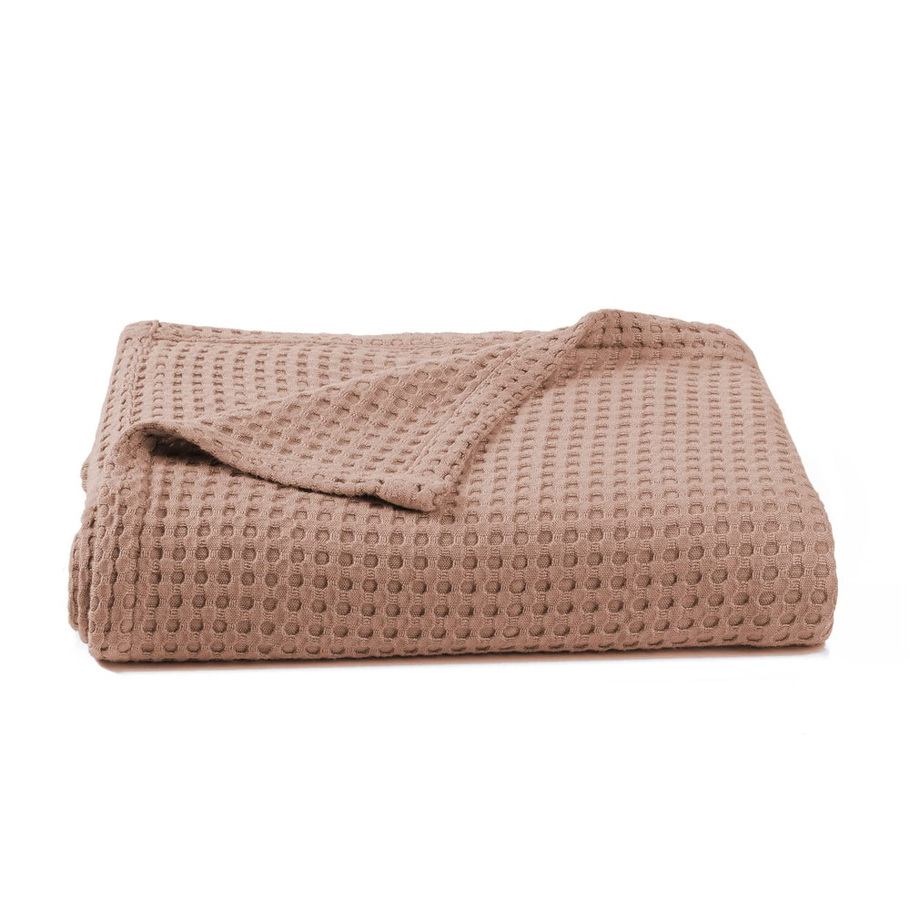 Kloovete blanket close-up shows soft waffle weave, clay color, gentle touch