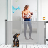 KYXAIN retractable baby gate in grey fits doorways up to 71 inches wide for flexible safety.