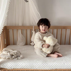 La Sheer fuzzy crib sheets — elastic banding visible for secure, slip-free fit.