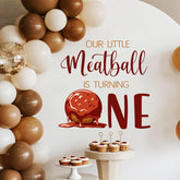 LANKBACK Our Little Meatball Turning One decal provides a festive backdrop for photos.