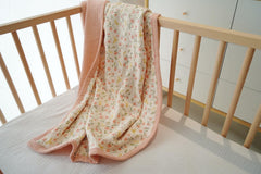 Little Jump peach floral blanket on crib demonstrates lightweight, breathable material ideal for warm days.