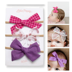 Little Poppy Co three hair bows on nylon headband flatlay for newborn outfits