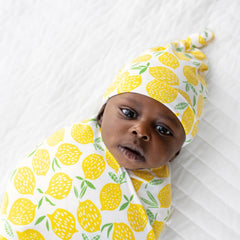 Little Sleepies Lemons swaddle used as stroller shade for sunny outings.