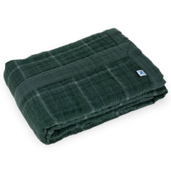 Little Unicorn Evergreen plaid muslin quilt used as a playtime blanket, soft and breathable
